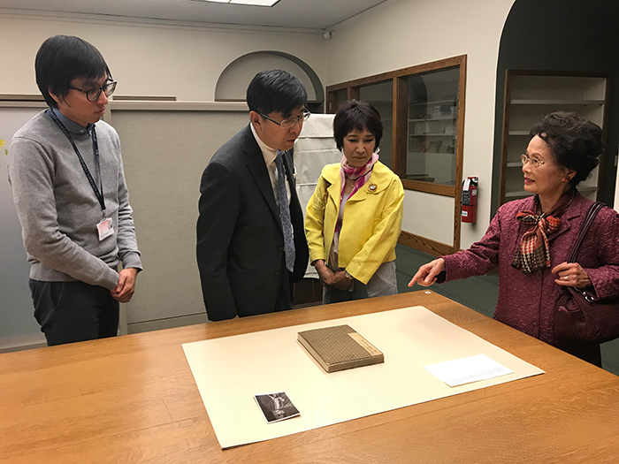 Akira Chiba (middle left), the consul general of Japan in Los Angeles, and his wife, Yuko Chiba (middle right) look at a guest book for a welcome party organized by the Japanese Red Cross to honor Sir Frederick Treves, personal physician to King Edward VII, on May 3, 1904, in Tokyo. The guest book, which contains signatures by Akira Chiba’s great-grandfather, was acquired and recently donated to The Huntington by Frank and Toshie Mosher (Toshie Mosher is on the far right). Li Wei Yang (far left), is curator of Pacific Rim Collections. Photo by Jim Folsom.