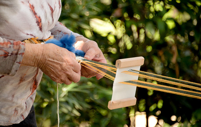 Weaving on a backstrap loom. Photo by Deborah Miller.