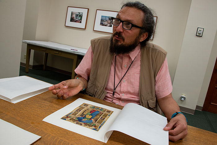 Artist Mario Ybarra Jr. looks through a collection of 15th- and 16th-century Italian illuminated manuscripts. The Huntington Library, Art Collections, and Botanical Gardens. Photo by Kate Lain.