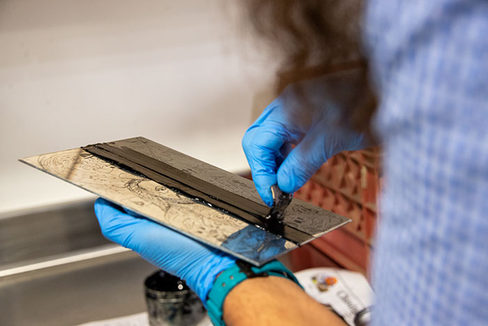 Ybarra inks a printing plate etched with his self-portrait. Photo by Kate Lain.