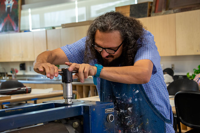 Ybarra adjusts the printer. Photo by Kate Lain.