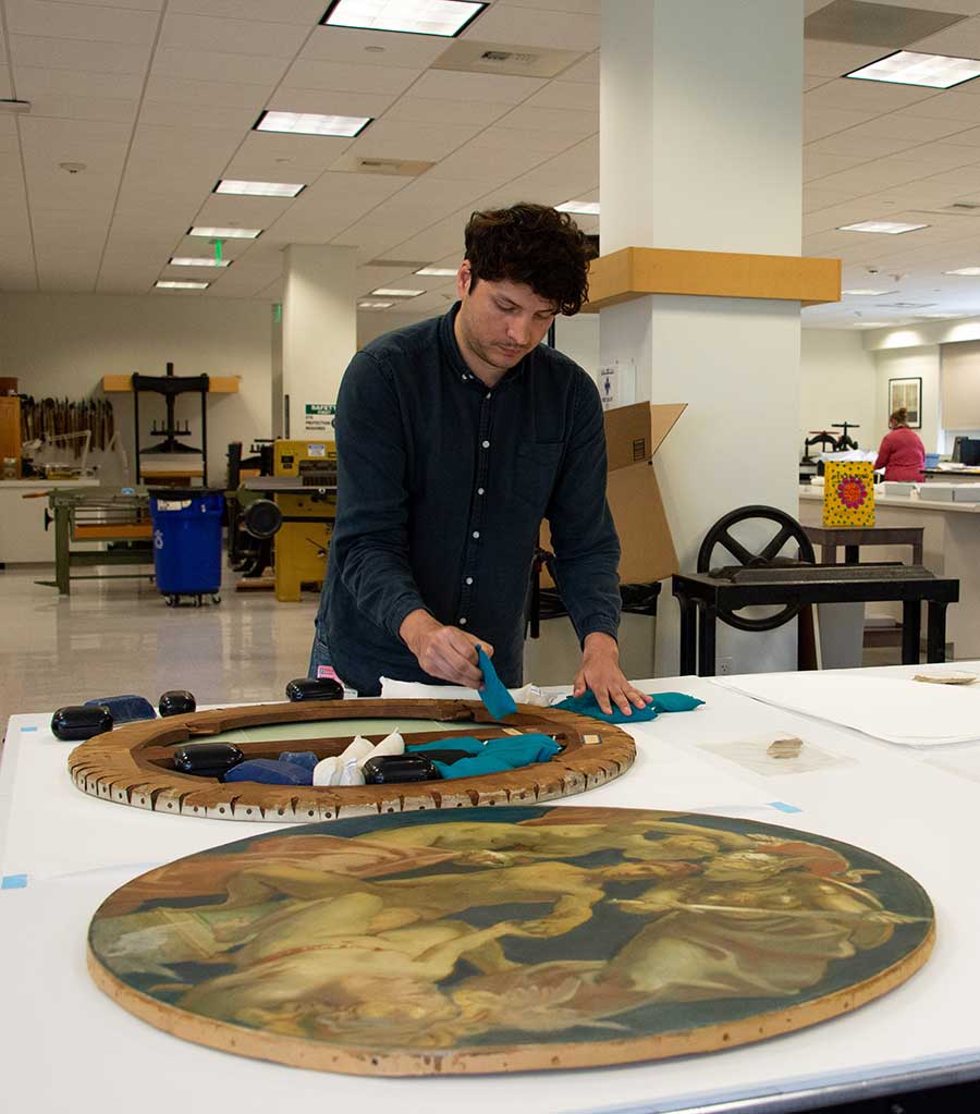 Jose Luis Lazarte, research scholar in paintings conservation at The Metropolitan Museum of Art in New York City, applies small weights to the back of an oil study, Sphinx and Chimaera (1916–1921), by John Singer Sargent, to address the canvas’s undulation issues. Photo by Deborah Miller.