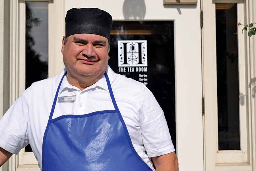 Mario Ahumada poses with pride outside his workplace, The Huntington’s Rose Garden Tea Room. Photo by Lindsey Harrison. Courtesy of Villa Esperanza Services.