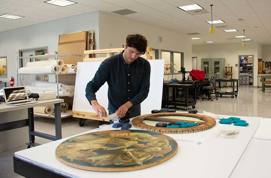 José Luis Lazarte, a research scholar in paintings conservation at The Metropolitan Museum of Art in New York City, weights the back of Sargent’s Sphinx and Chimaera. Photographs by Deborah Miller.