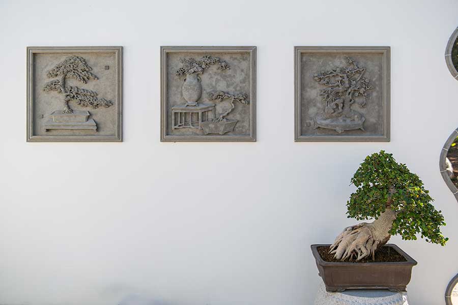 Handcrafted tiles illustrating the art of penjing grace the walls of the new display. Photo by Jamie Pham.