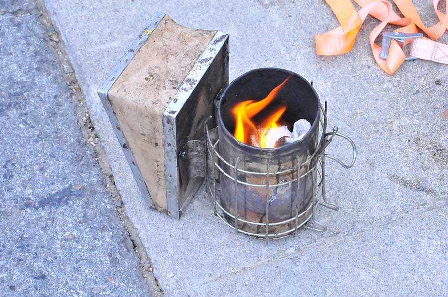 Heydman fires up a smoker that he uses to encourage bees to leave their established hive. Photo by Andrew Mitchell.